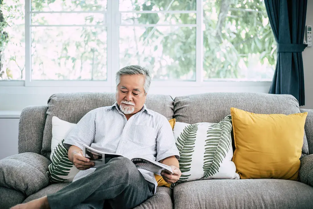 An elderly resident enjoying a serene moment in a beautifully designed living space at Ashirwad Elders Home, surrounded by warmth and comfort