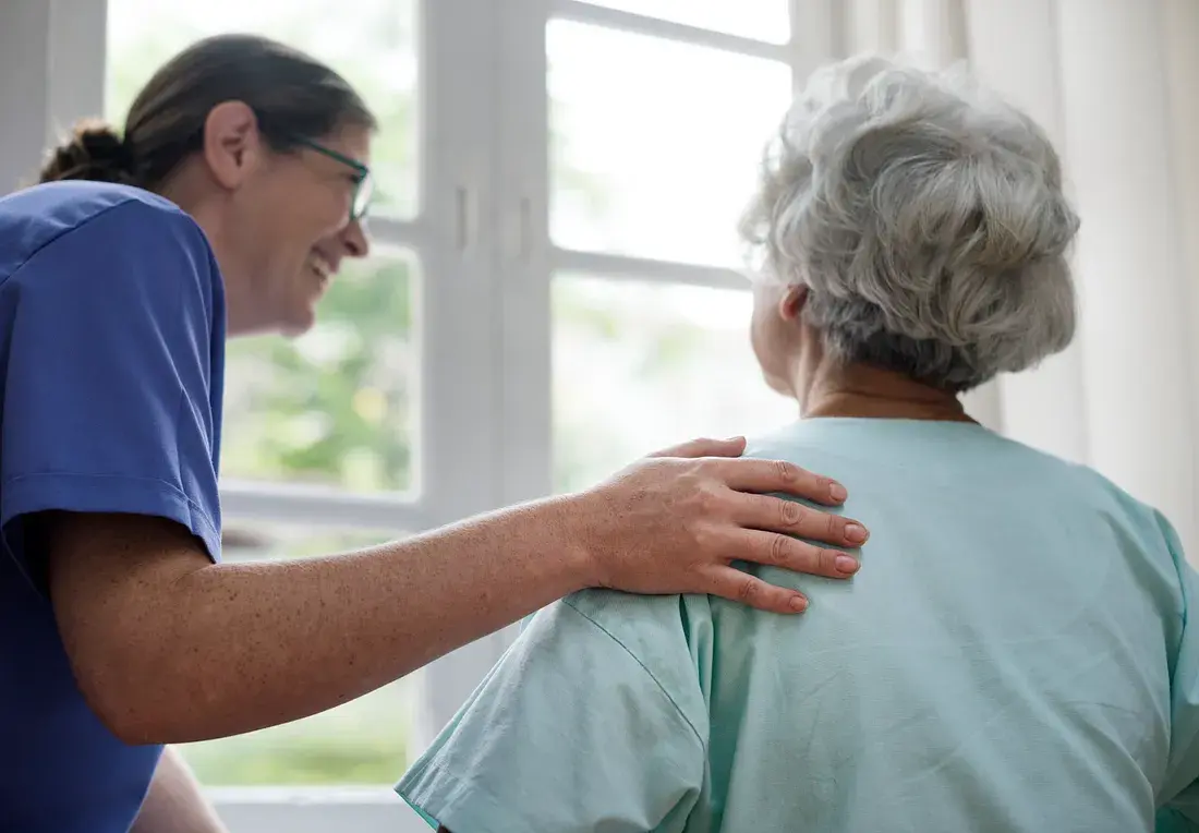 A caregiver at Ashirwad Elders Home offering comforting support to an elderly resident, reflecting compassion and attentiveness